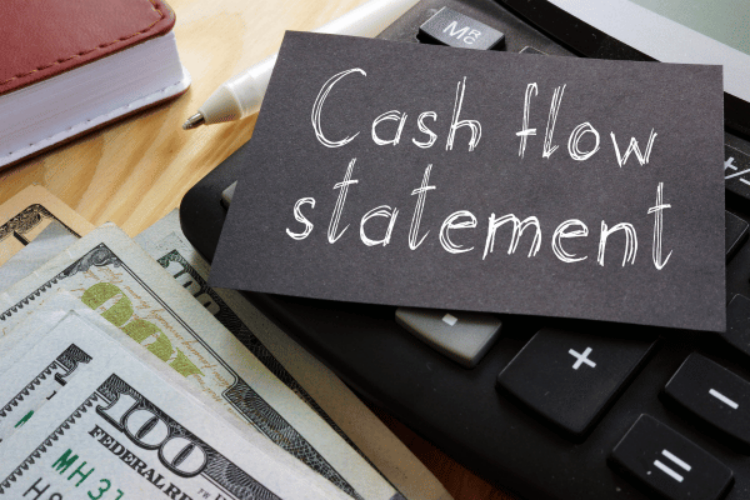 A cash flow statement and some money are lying on the desk.